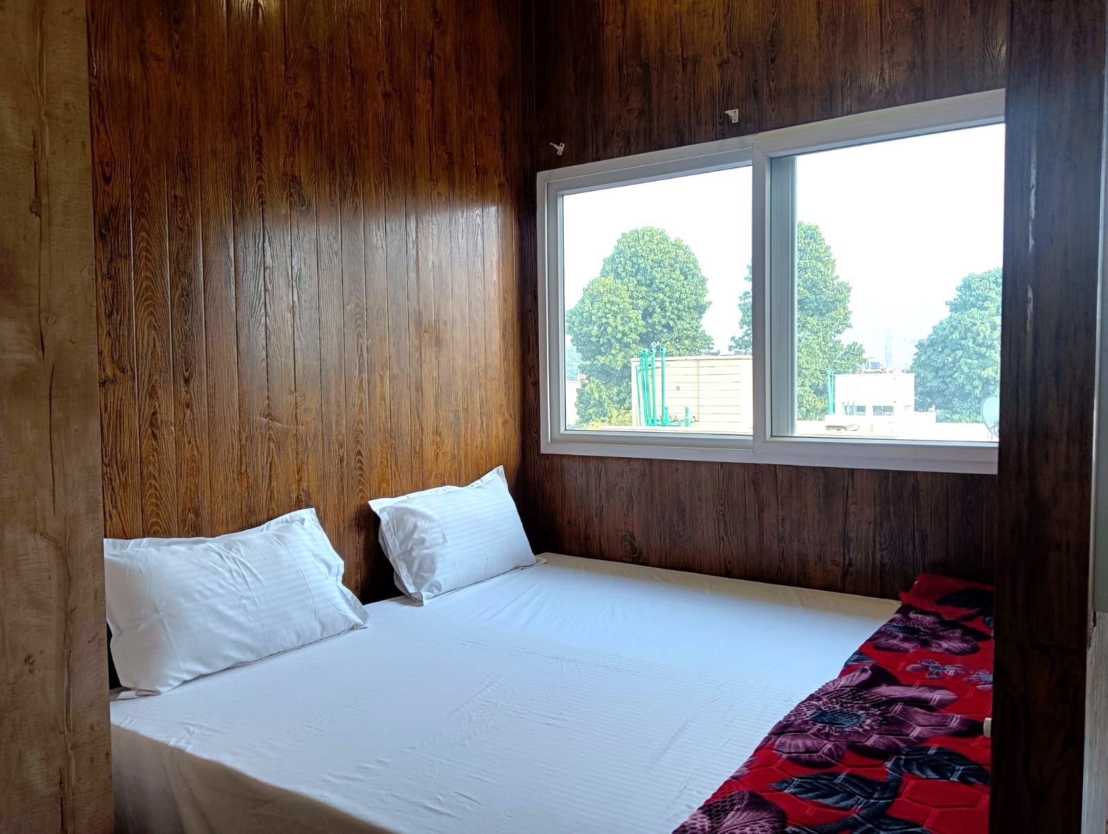 Furnished bedroom with study desk and natural light at Sukh Vaas